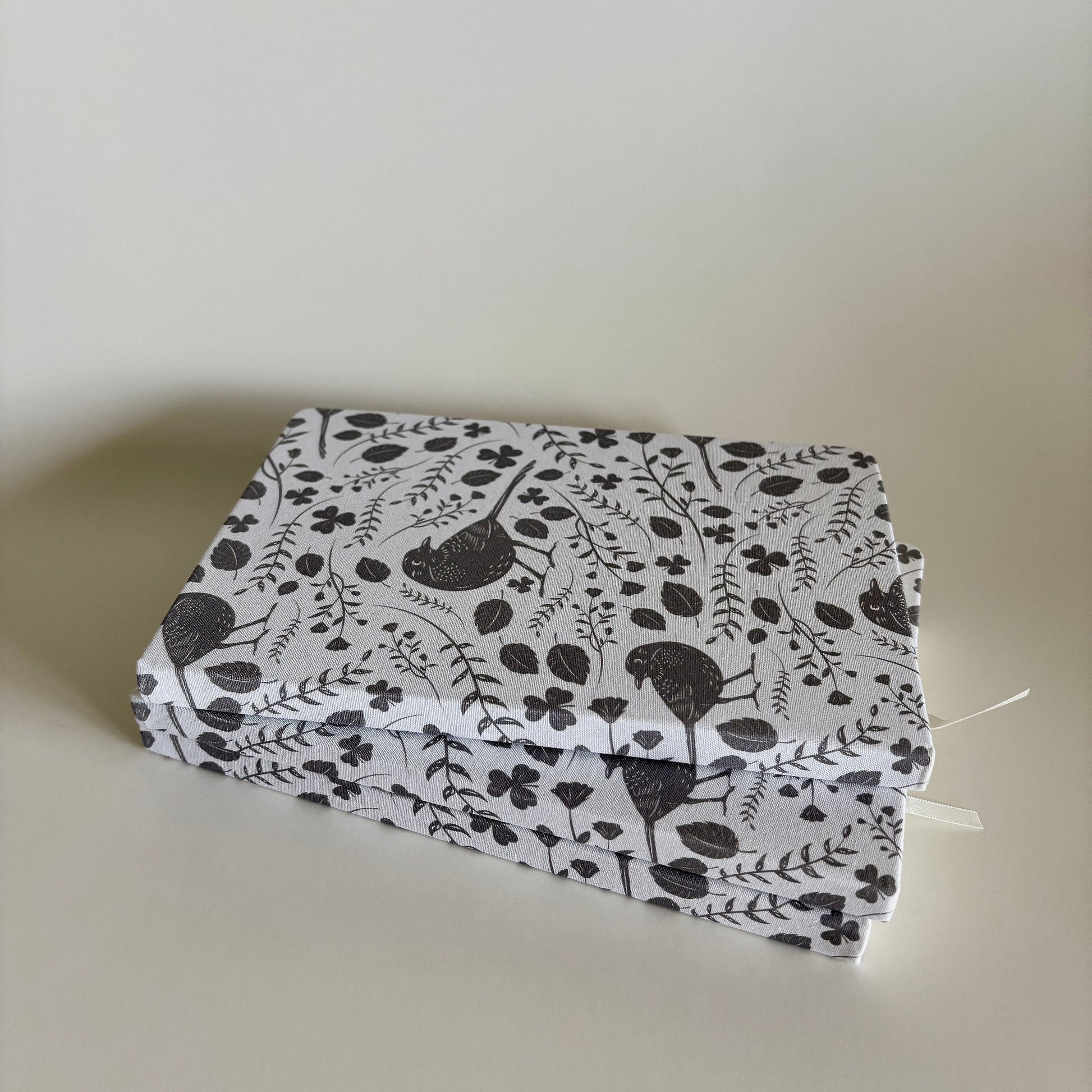 Stack of blackbird notebooks made from  100% recycled, tree-free materials including repurposed fabric, paper waste, soft cotton, and bamboo scraps.