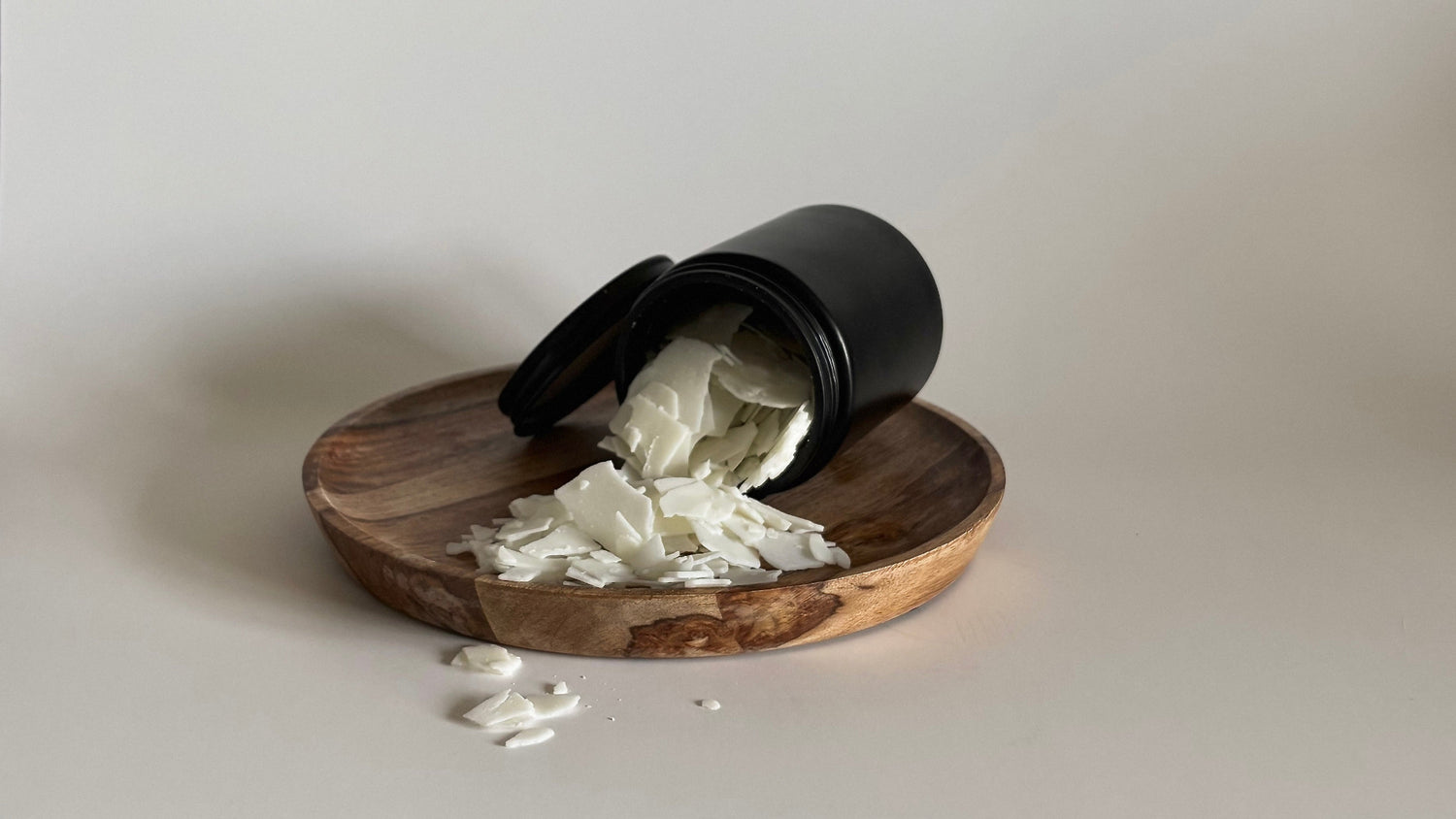 Blackett & Co. soy wax flakes spilled across a wooden plate