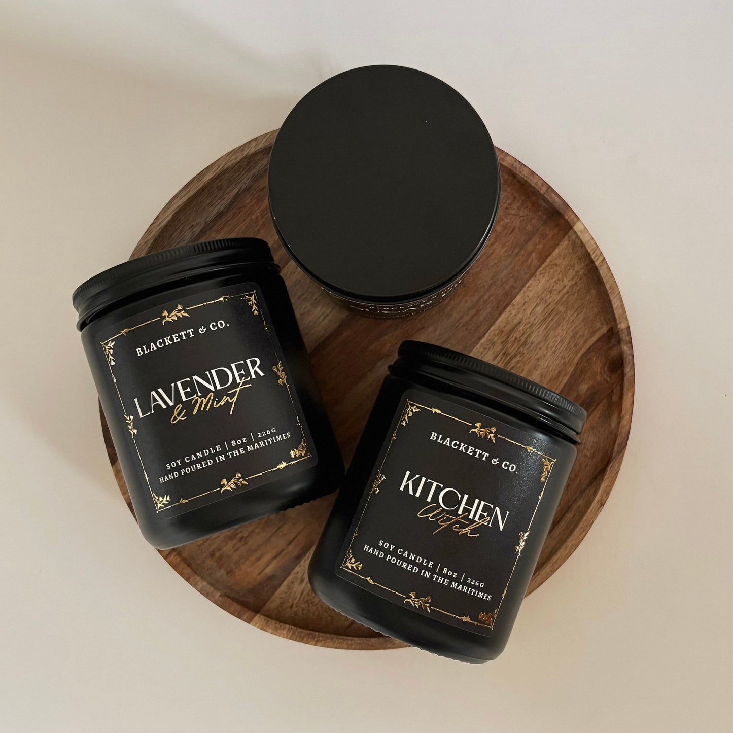 Kitchen Witch and Lavender & Mint scented natural soy candles on a wooden board against a white background