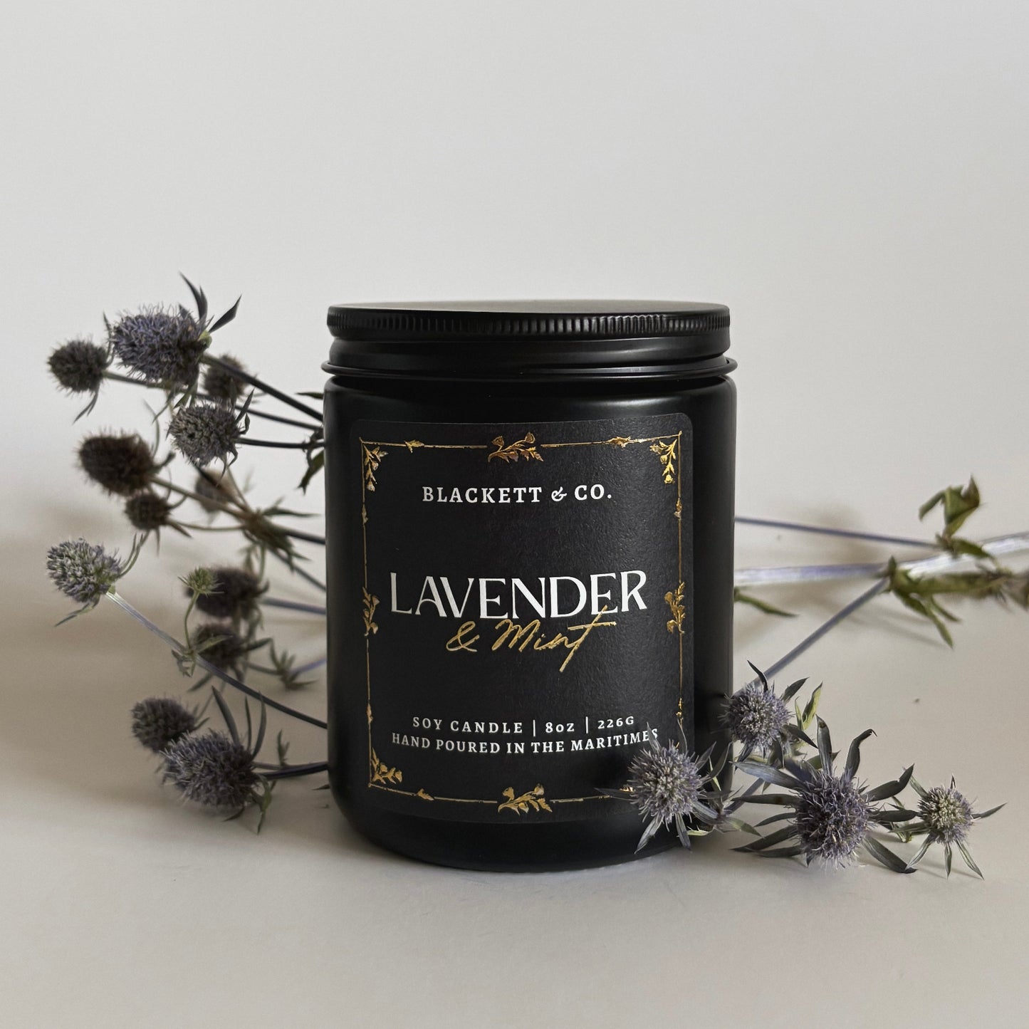 Lavender & Mint scented natural soy candle by Blackett & Co. surrounded with Nova Scotia thistle