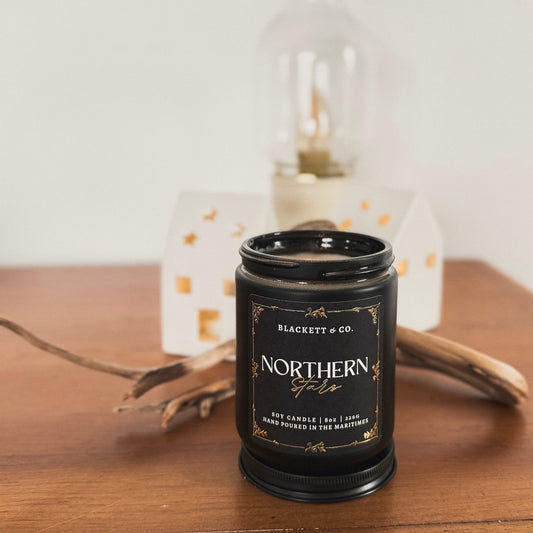 Northern Stars scented natural soy candle with ceramic ornaments and drift wood in the background