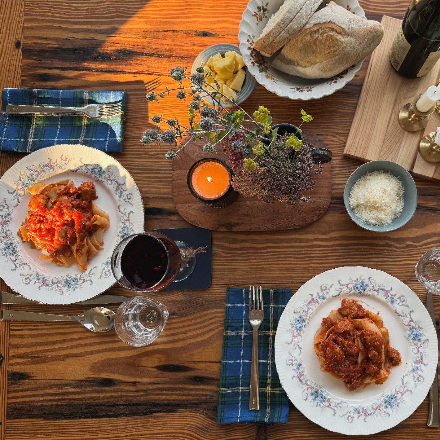 Pure unscented natural soy candle on a dining table set with plates of food, cutlery, and glassware