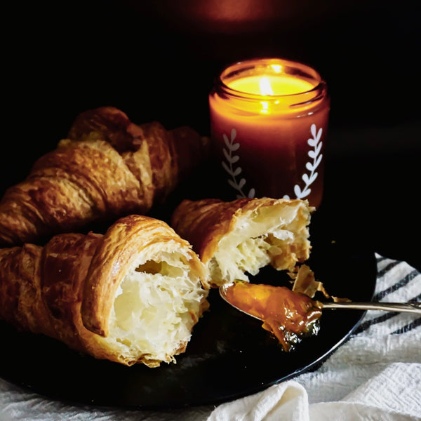 Autumn Sunday Glow soy candle, surrounded by croissants, Blackett & Co. soy candles handmade in Halifax, Nova Scotia