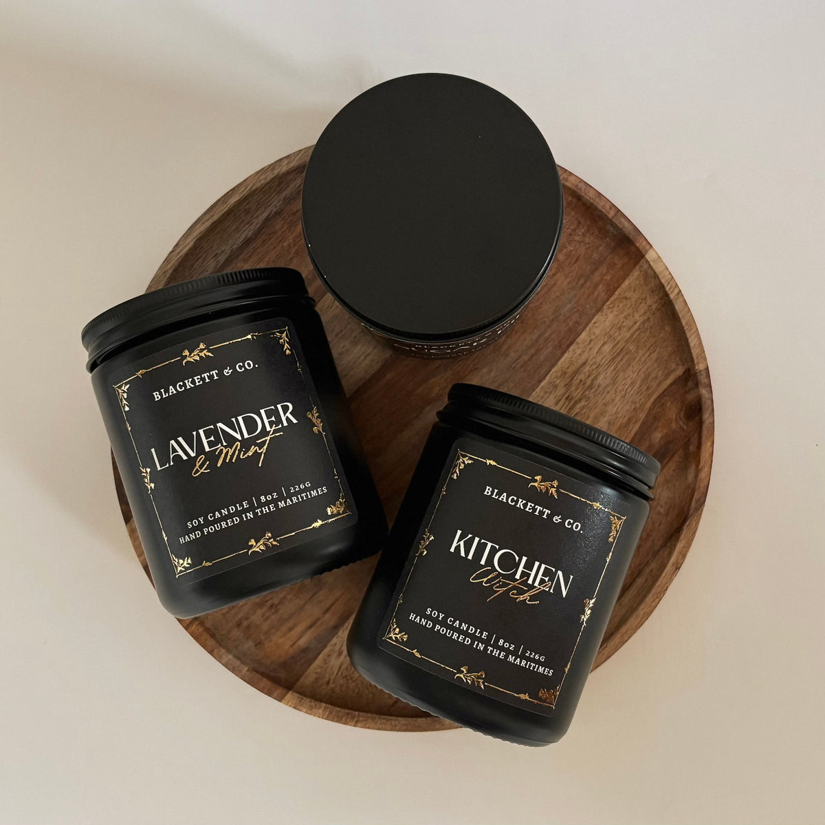 Kitchen Witch and Lavender & Mint scented natural soy candles on a wooden board against a white background