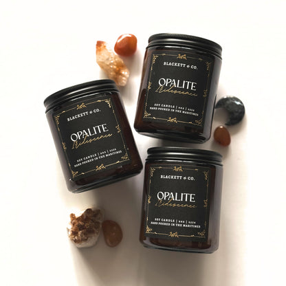 Three Opalite Iridescence scented natural soy candles handmade by Blackett & Co. with decorative stones and crystals on a white background.