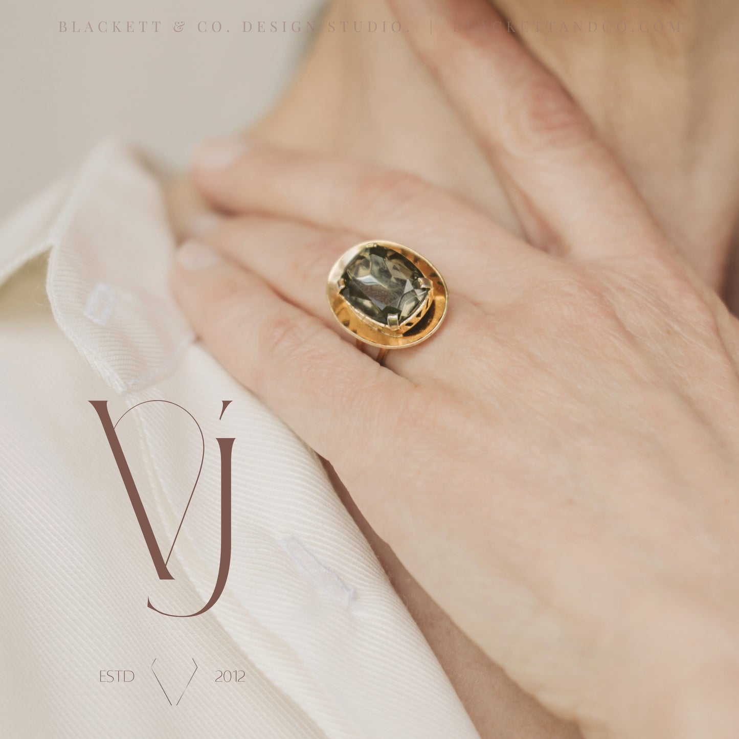 Vela brand logo design by Blackett & Co. on a jewellery product photo featuring a green and gold ring.