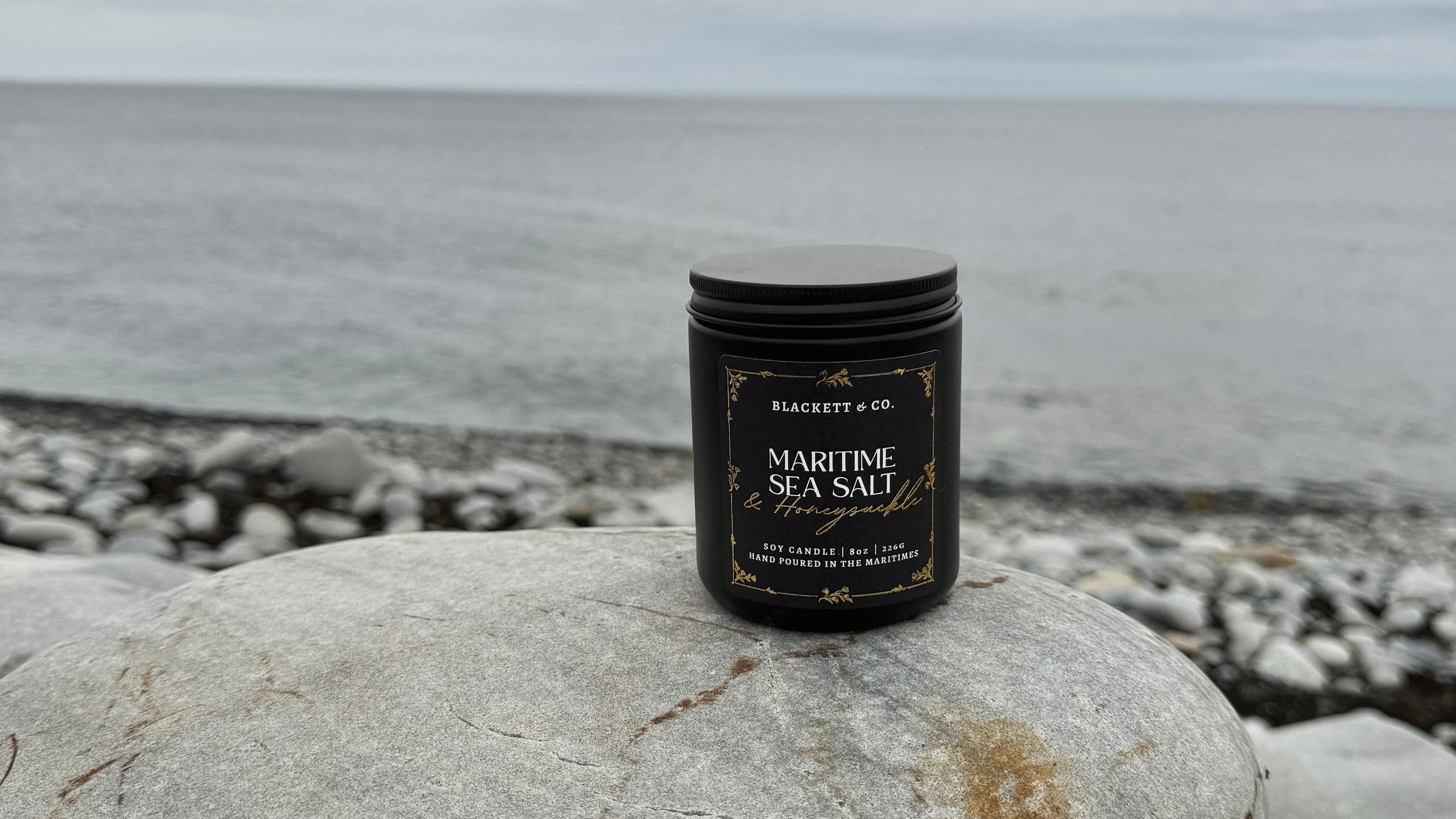 Load video: Video reel showcasing Blackett &amp; Co. scented natural soy candle Maritime Sea Salt &amp; Honeysuckle with a poem authored by K.A. Popwell being read